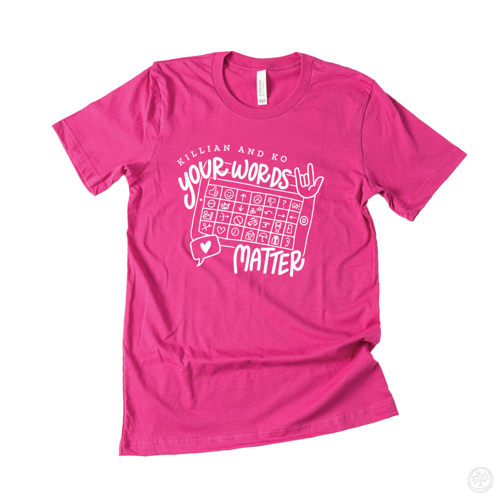 Hot pink t-shirt with white text reading “Killian and Ko – Your Words Matter” above a speech device illustration – nonprofit tee promoting communication inclusion and AAC awareness.