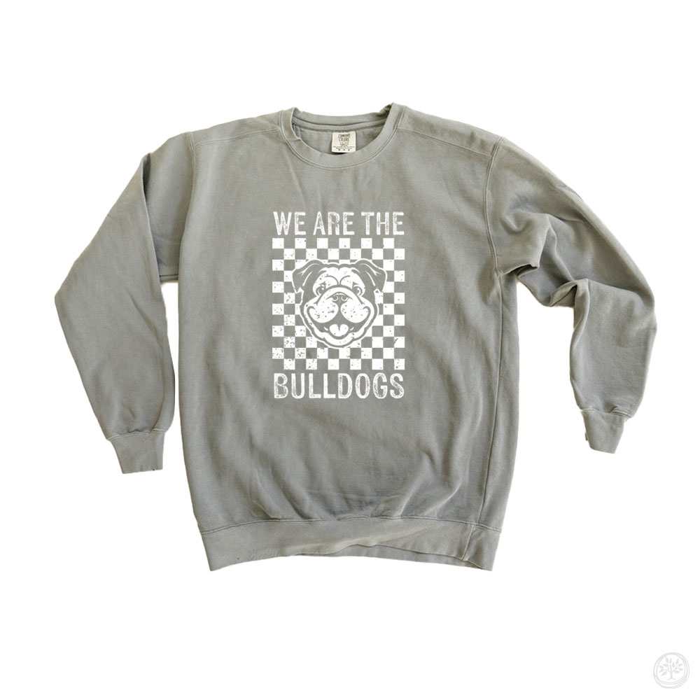 Gray crewneck sweatshirt featuring a checkered pattern and smiling bulldog mascot with white text reading “We Are the Bulldogs” – spirit wear design celebrating school pride and unity.